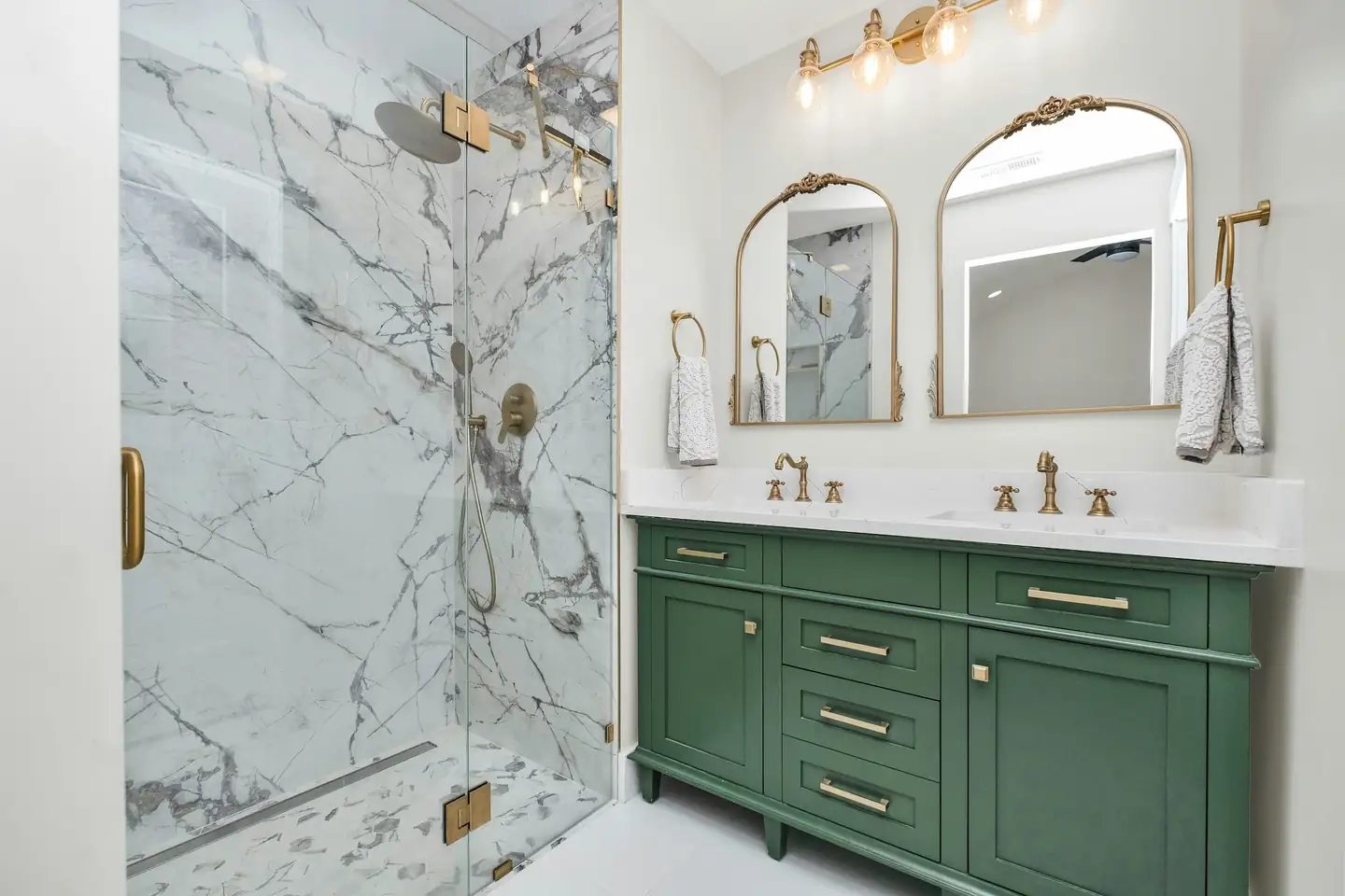 Salle de bain avec douche vitrée en grand format effet marbre et meuble vasque vert