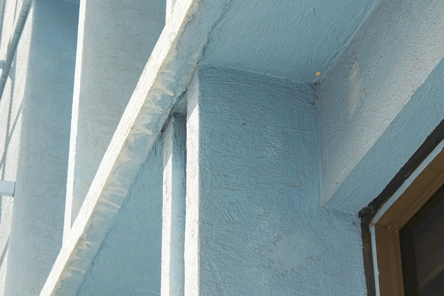 Angle de façade enduit en gris bleuté, retour d’isolant autour d’une baie