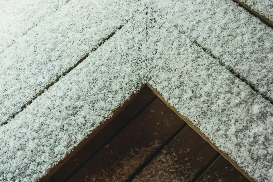 Fine couche de neige sur un toit en bardeaux, au-dessus d’une avancée de toit