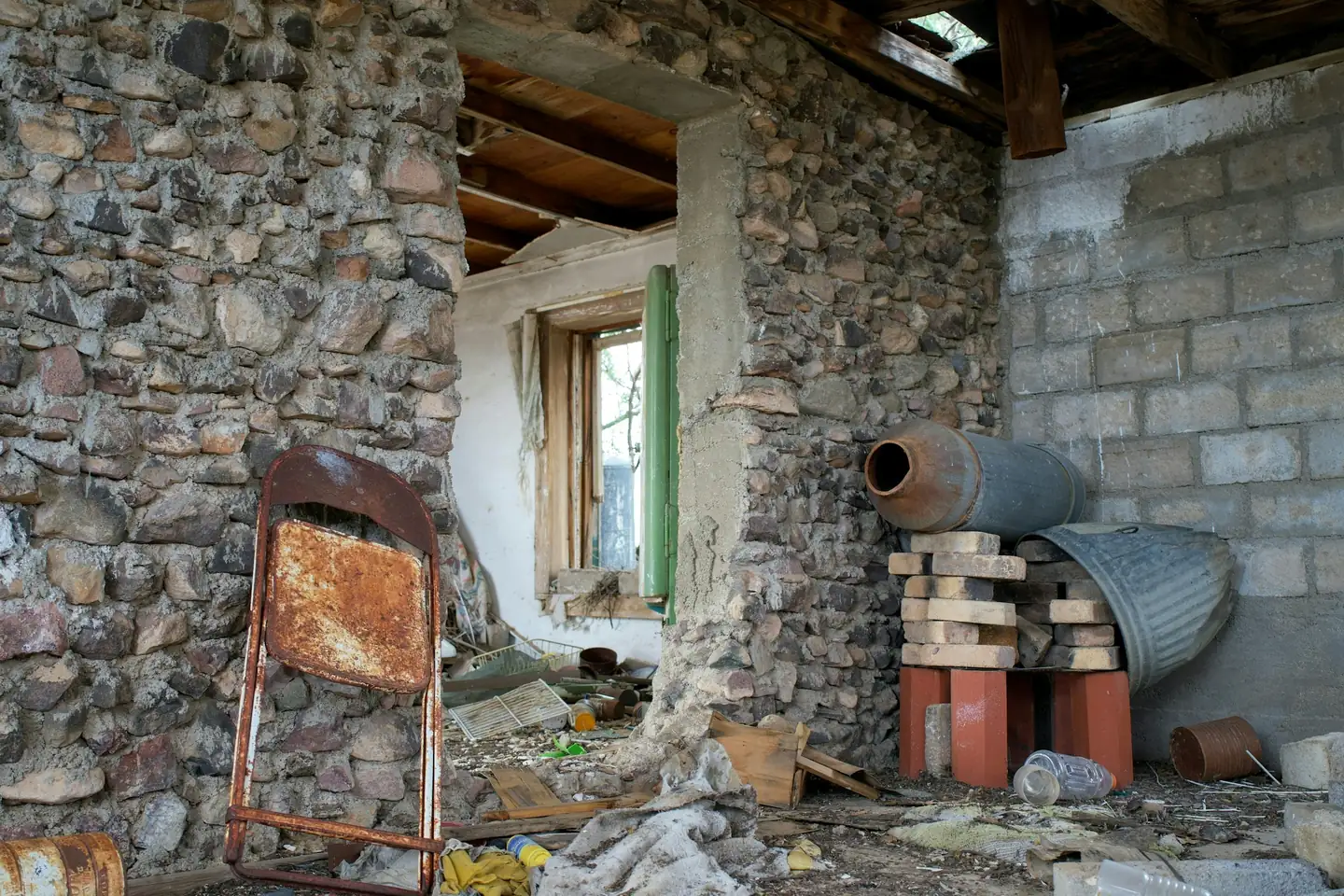 Pièce vidée avant travaux, maçonnerie de pierre mise à nu autour d’une fenêtre
